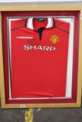 A pre-owned Brian Robson signed Man United football shirt (Item in a damaged frame, may be