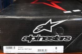 A pair of Alpinestars Tech 7 motocross boots in black, silver, white and gold (Size US 8 / EU 42).