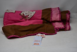 An as new Karen Mabon X Peter Rabbit woven raspberry blanket, part of a limited-edition capsule