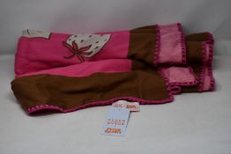 An as new Karen Mabon X Peter Rabbit woven raspberry blanket, part of a limited-edition capsule