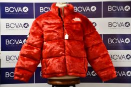 An as new Supreme The North Face Faux Fur Nuptse jacket in red (L - No tags but item as new).