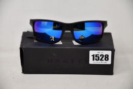 A pair of as new Oakley Gibston sunglasses.