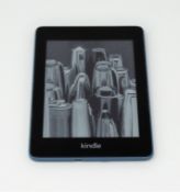 A pre-owned Amazon Kindle Paperwhite (M/N: PQ94WIF) in Teal.