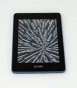 A pre-owned Amazon Kindle Paperwhite (M/N: PQ94WIF) in Teal.