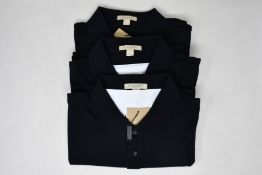 Three as new Burberry polo shirts in black (L).