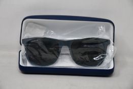 A pair of as new Lacoste sunglasses.