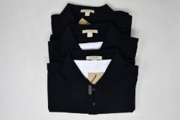 Two as new Burberry polo shirts in black (L).