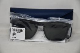 A pair of as new Lacoste sunglasses.