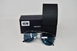 A pair of as new Prada sunglasses (Crack in the left lens).