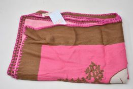 An as new Karen Mabon X Peter Rabbit woven raspberry blanket, part of a limited-edition capsule