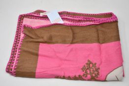 An as new Karen Mabon X Peter Rabbit woven raspberry blanket, part of a limited-edition capsule