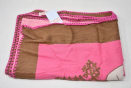 An as new Karen Mabon X Peter Rabbit woven raspberry blanket, part of a limited-edition capsule