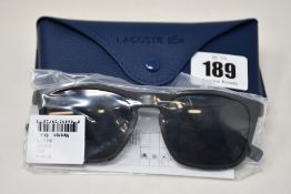 A pair of as new Lacoste sunglasses.