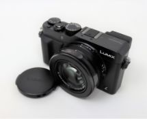 A boxed as new Panasonic Lumix DMC-LX100 Premium Compact Camera (Box opened, UK plug included).