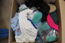 A box of as new golf clothing items and hats.