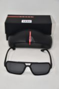 A pair of as new Prada sunglasses.