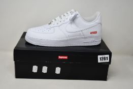 A pair of as new Nike x Supreme Air Force 1 Low with authentication tag (UK 7.5).