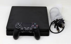 A pre-owned Sony PlayStation 4 500GB games console in black. One controller and HDMI/power cables su