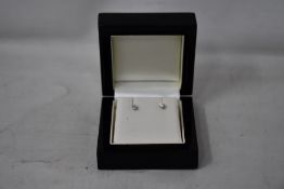 A pair of diamond stud earrings.