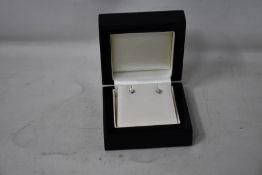 A pair of diamond stud earrings.