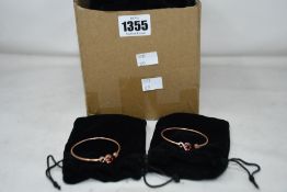 A quantity of copper effect bangles in gift bags (Approximately 50 items).