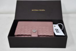 A Bottega Veneta Intrecciato leather passport holder with strap and box (Possibly pre-owned but