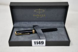 A Parker Sonnet Rollerball pen in black lacquer and gold trims.