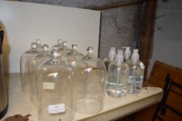 Seven Glass Bell Covers and Four Bottles of Hand S