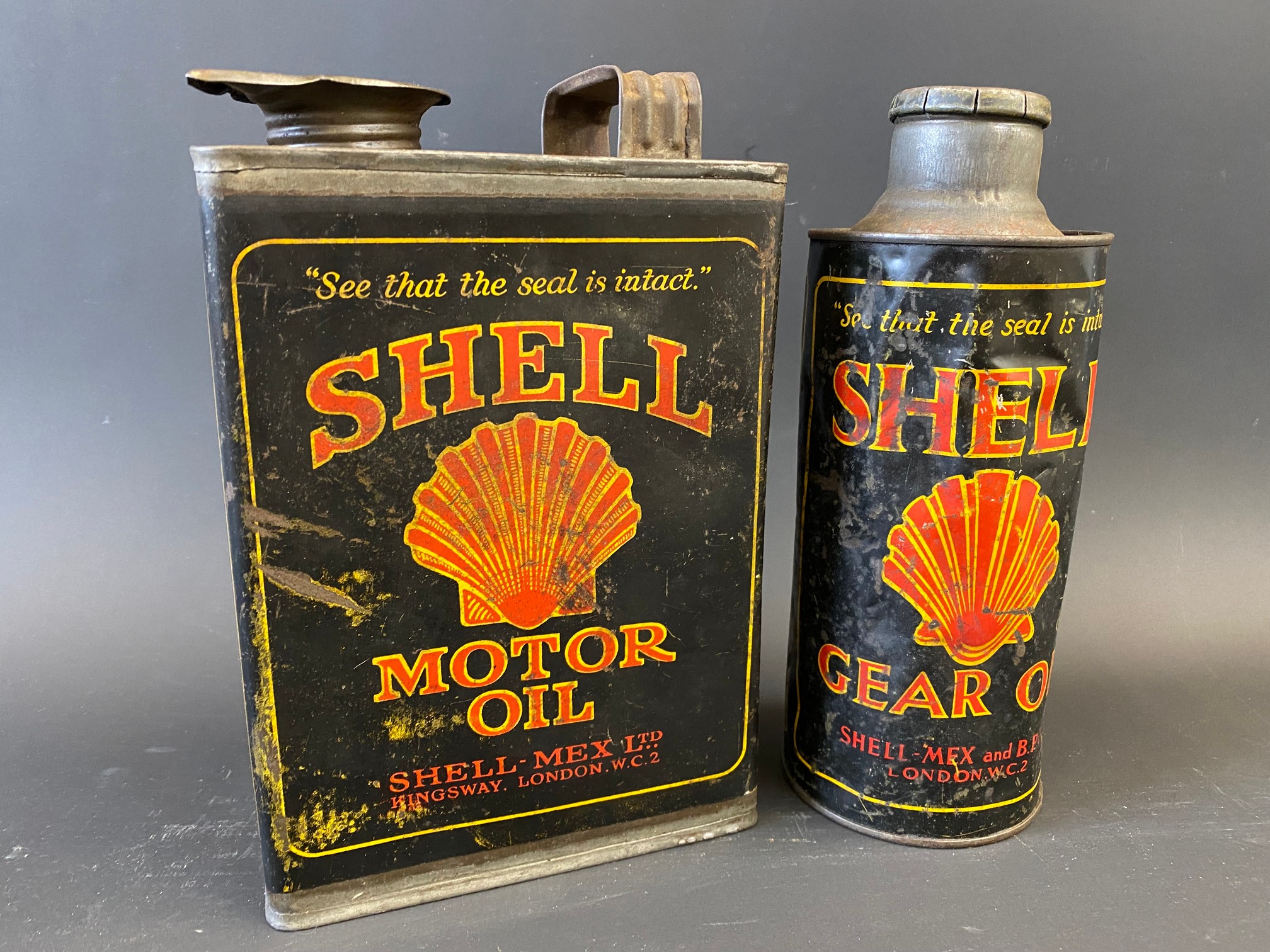 A Shell Motor Oil half gallon can, plus a Shell Gear Oil cylindrical quart can, with original cap.