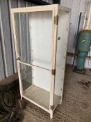 A tall metal framed front opening display cabinet, probably formerly pharmacy related, 30