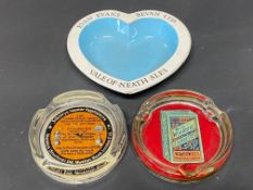 A Wills Wild Woodbines glass ashtray and two others.