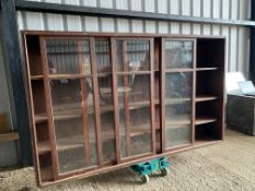 A large stained pine display cabinet with five sliding glass doors, 89 1/4