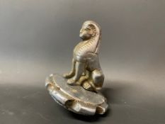 An Armstrong Siddeley sphinx radiator mascot on a cap.