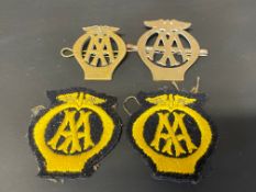 Two small AA brass cap/lapel badges plus two similar cloth badges.