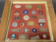 A framed and glazed collection of enamel and brass dash mounted supply plates, many Pembrokeshire