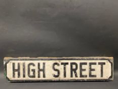 A cast metal road sign for High Street, mounted on a piece of wood, 30 1/2 x 7