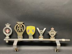 A chrome plated badge bar with five badges attached including K.G.L Dansk Automobil Klub.