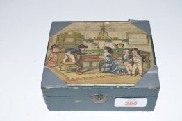 A small flip-top box, the lid decorated with scene of children playing billiards, containing a
