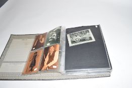 Grey lever arch file containing a collection of various black and white photographs and prints,