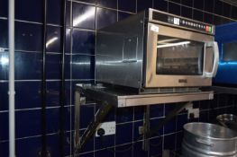 Buffalo commercial microwave oven together with a stainless steel shelf