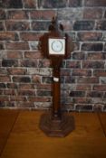 Small mantel clock mounted on a turned wooden pedestal