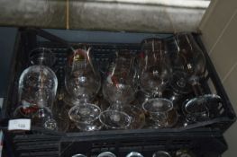 Box containing mixed branded pint glasses to include Moretti and San Miguel