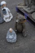 Two composite garden statues, one of a Buddha and one of a bear