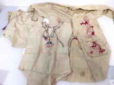 A pair of early 20thc embroidered tunics, both with of floral design and a tunic with Chinese