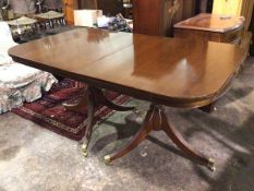 A modern mahogany twin pedestal dining table, the rectangular top with rounded edges, on turned