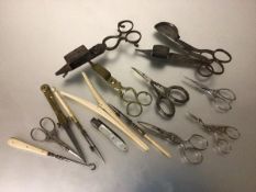 A collection of four various wick trimmers, miscellaneous nail scissors, glove stretchers, drawing