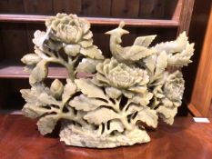 A Chinese jadeite carving depicting a bird amongst flowering shrub (38cm x 50cm x 11cm)