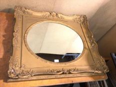 A wall mirror, the oval glass within a gilt rectangular frame (73cm x 84cm)