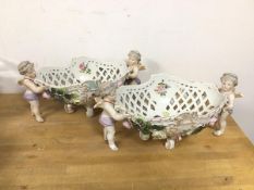 A pair of German pierced baskets, with foliate decoration and cherub supports (each: 16cm x 32cm x