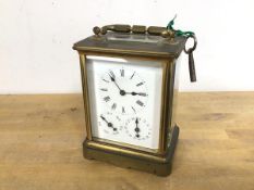 A brass and glass carriage clock with glass to top and four sides, the face with roman numerals to